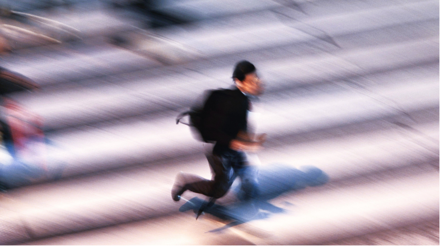 Artistic blurred shot of a man in motion running up stairs, capturing dynamic movement.